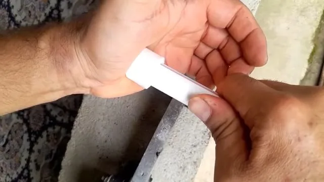 Cutting white pex repair tube to length during residential plumbing work in Kingman, AZ