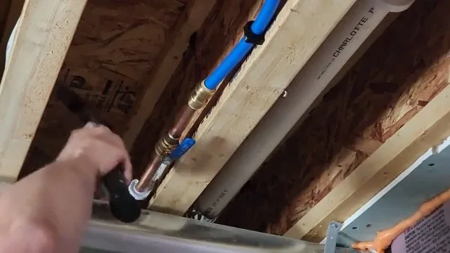 Installing blue and red pex lines in joists during residential plumbing work in Kingman, AZ